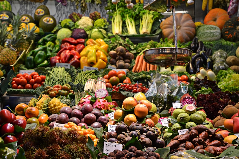 A market stall piled high with colorful fruits and vegetables in wooden crates.