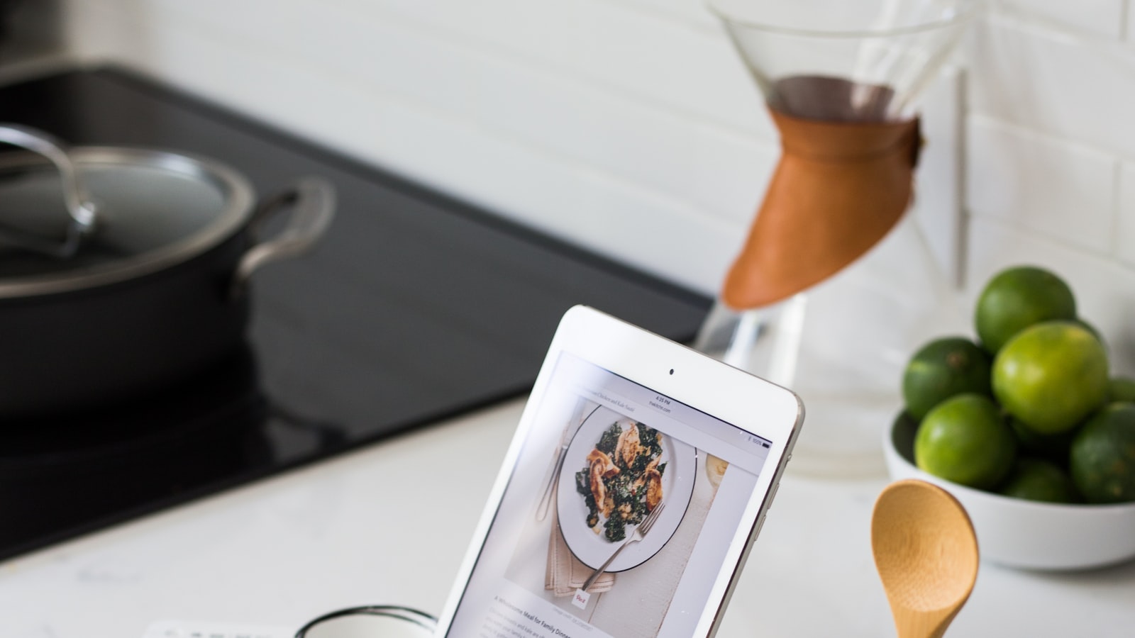 An open recipe book on a counter beside measured ingredients in small bowls.