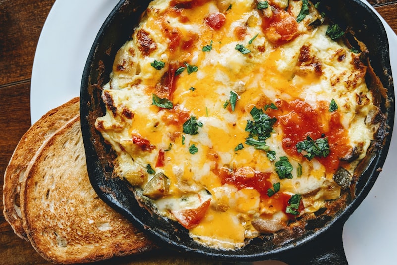 A soft folded omelette on a white plate with a fork beside it.